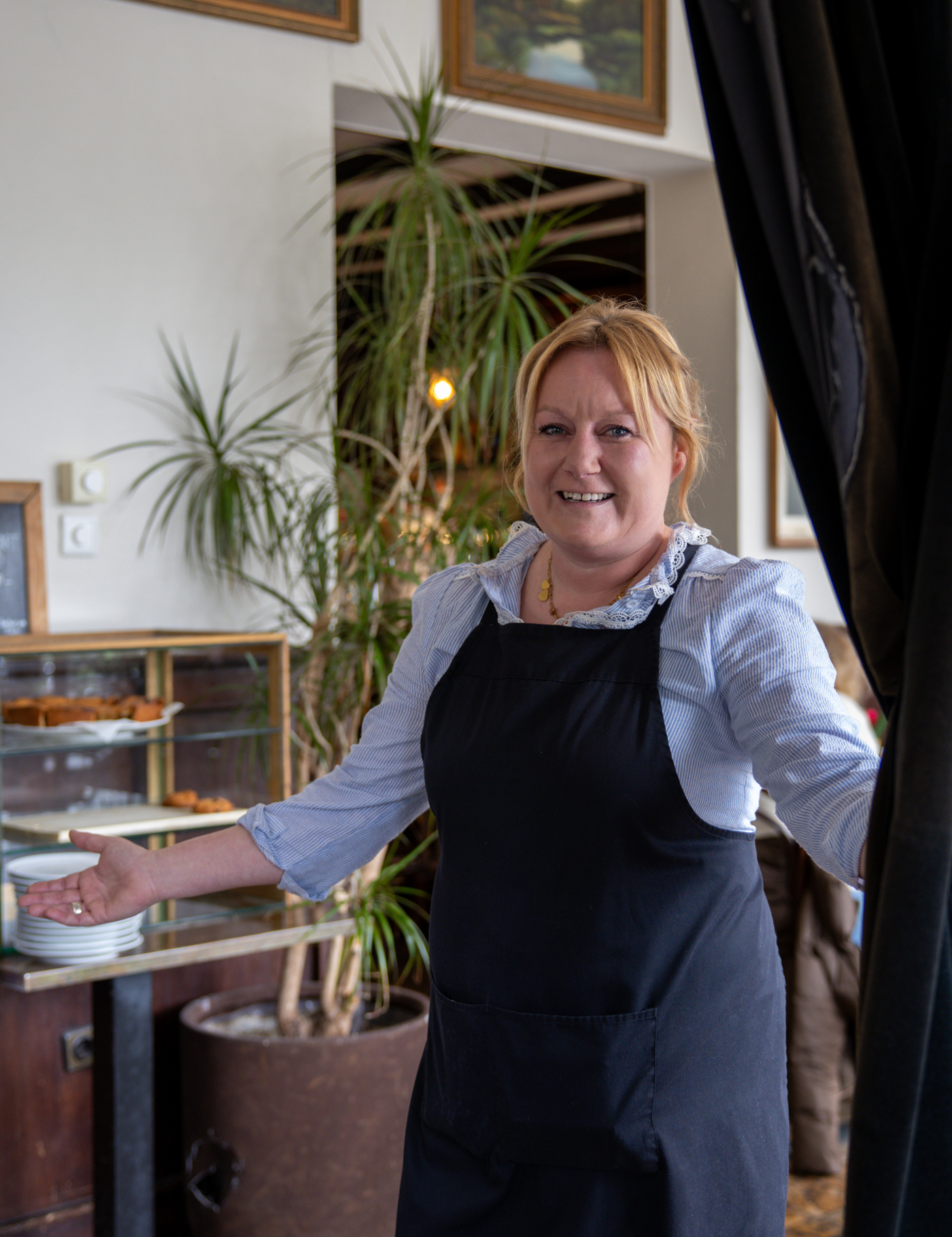 Een vrolijk kijkende dame die proost met een ijsthee van De Eendracht